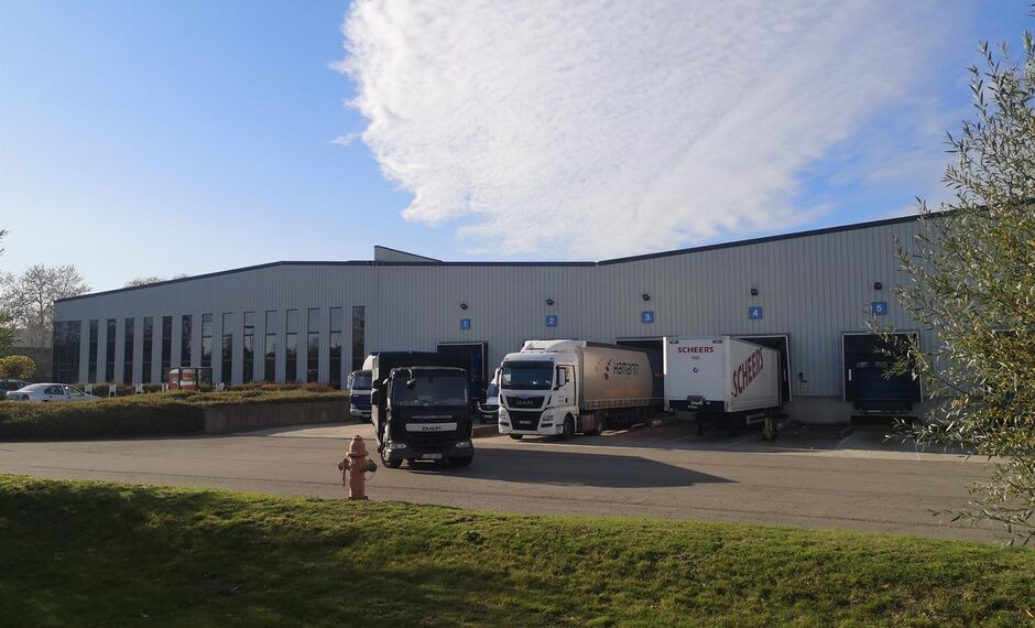 Het betreft een modern logistiek gebouw gelegen in de bedrijvenzone Pullaar te Puurs. De site ligt op het kruispunt tussen de N16 Mechelen - Sint-Niklaas en de A12 Antwerpen - Brussel, waardoor alle grote steden binnen de Vlaamse Ruit vlot bereikbaar zijn